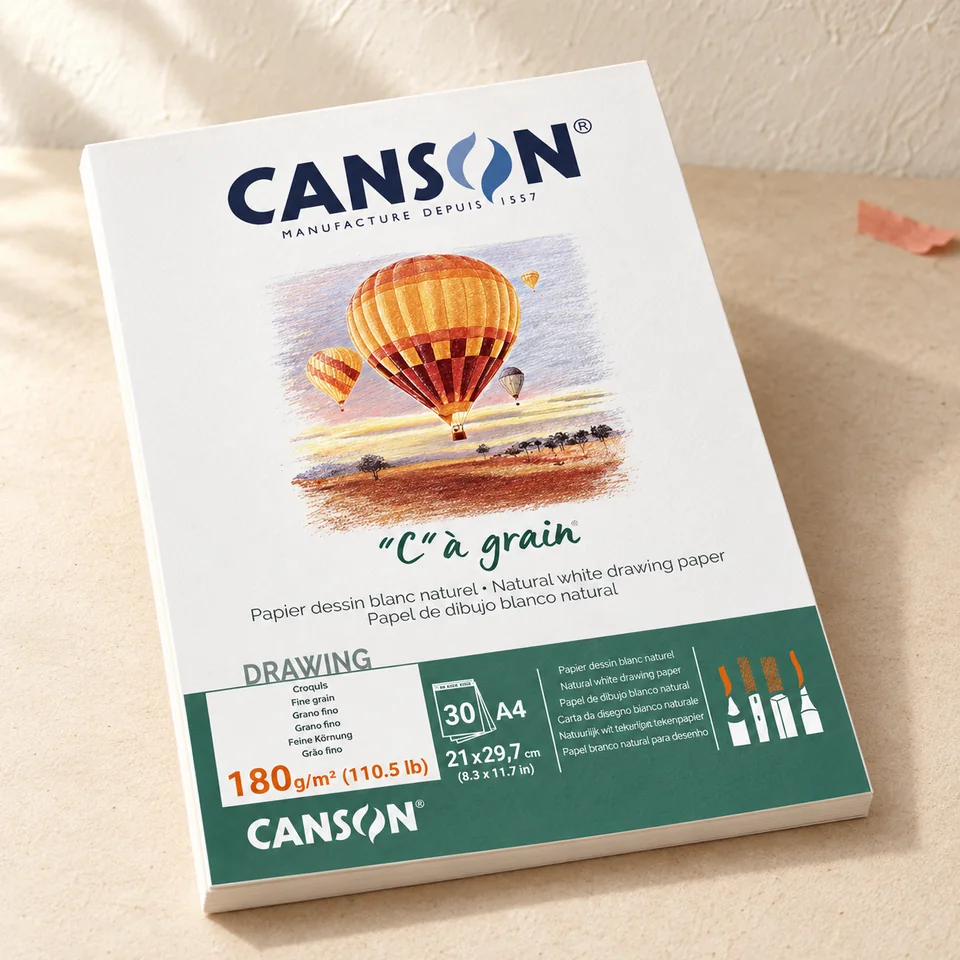 Canson — C à Grain A4 180 g de Canson, mise en situation dans un atelier de papier écru et corail