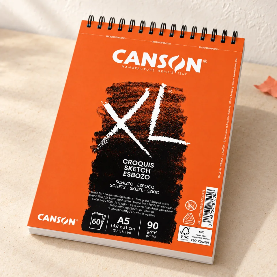 Canson — XL Croquis A5 ivoire de Canson, mise en situation dans un atelier de papier écru et corail