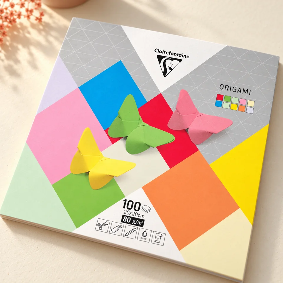 Clairefontaine — origami teinté dans la masse de Clairefontaine, mise en situation dans un atelier de papier écru et corail