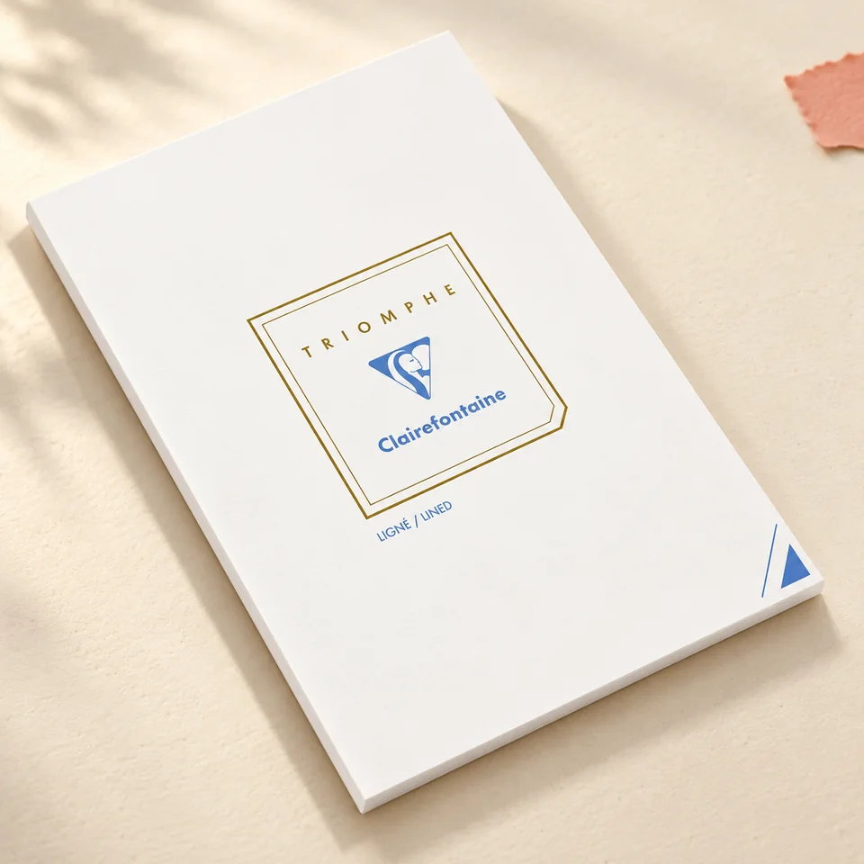 Clairefontaine — Triomphe A4 ligné, 50 feuilles de Clairefontaine, mise en situation dans un atelier de papier écru et corail