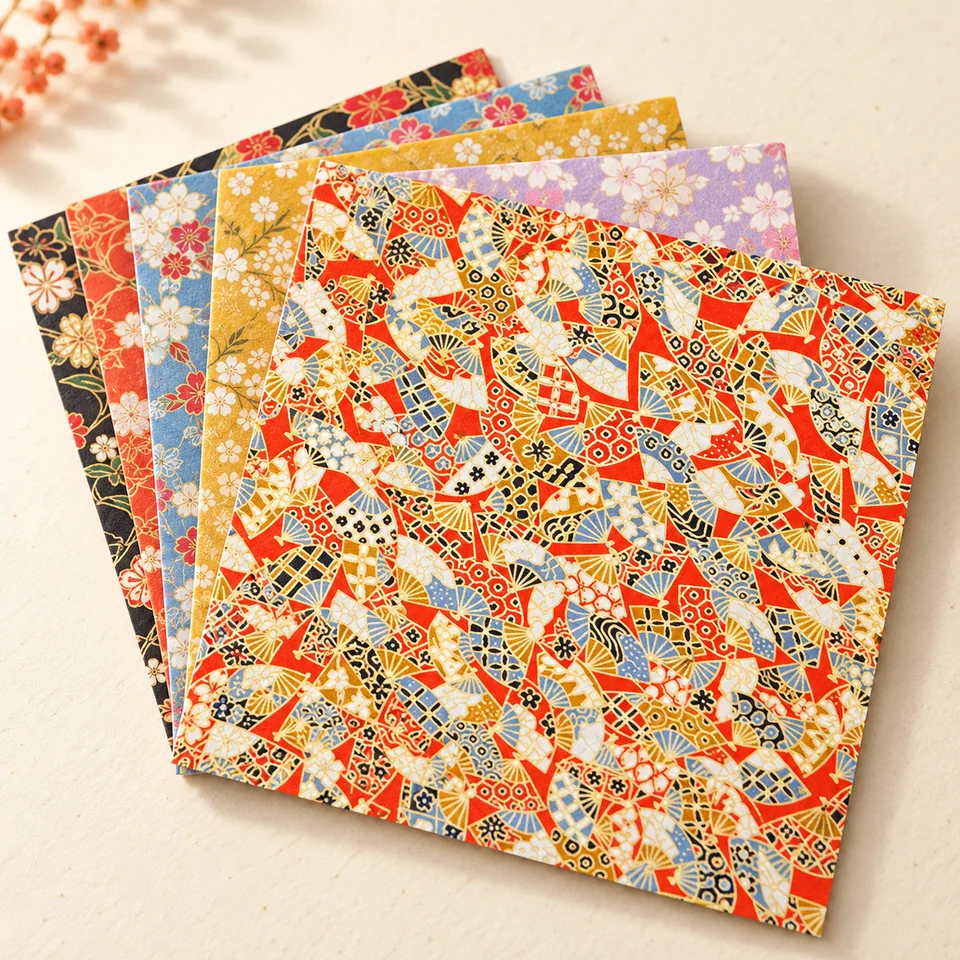 Heiyemon — assortiment Yuzen de 80 feuilles de Heiyemon, mise en situation dans un atelier de papier écru et corail