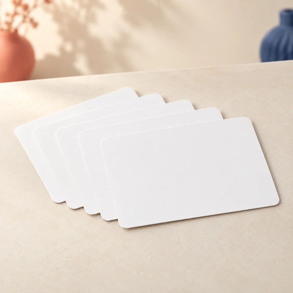 Leucasa — cartes A6 à coins arrondis de Leucasa, mise en situation dans un atelier de papier écru et corail