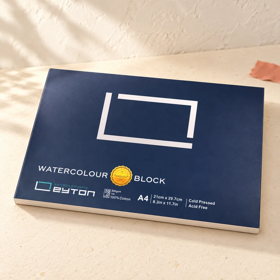 Leyton — aquarelle A4 collée sur quatre côtés de LEYTON, mise en situation dans un atelier de papier écru et corail