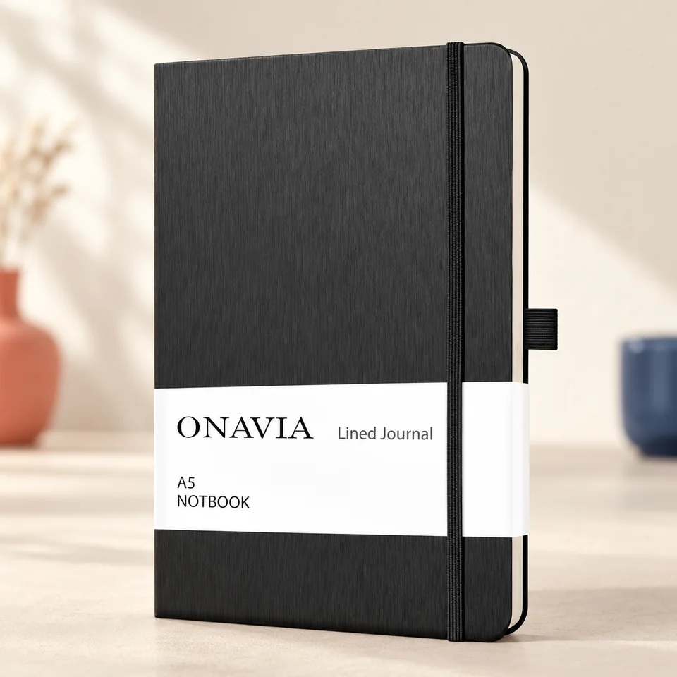 ONAVIA — carnet noir A5 de 160 pages de ONAVIA, mise en situation dans un atelier de papier écru et corail